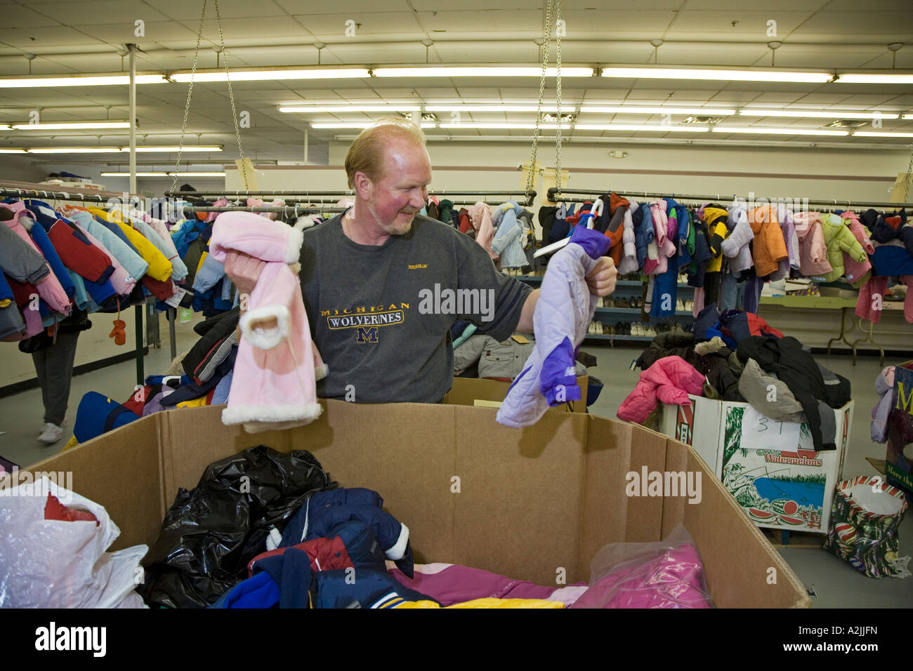 Volunteer Sorts Clothing for Needy Families Stock Photo