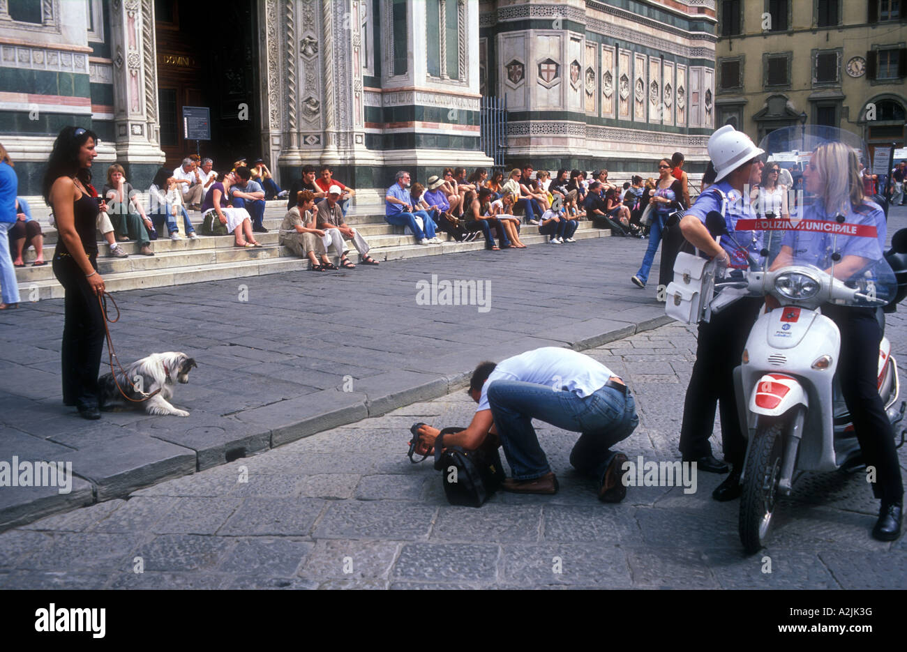 Italy Florence Cathedral of Santa Maria del Fiore The Duomo Piazza del Duomo tourist taking photos of girlfriend with dog Stock Photo