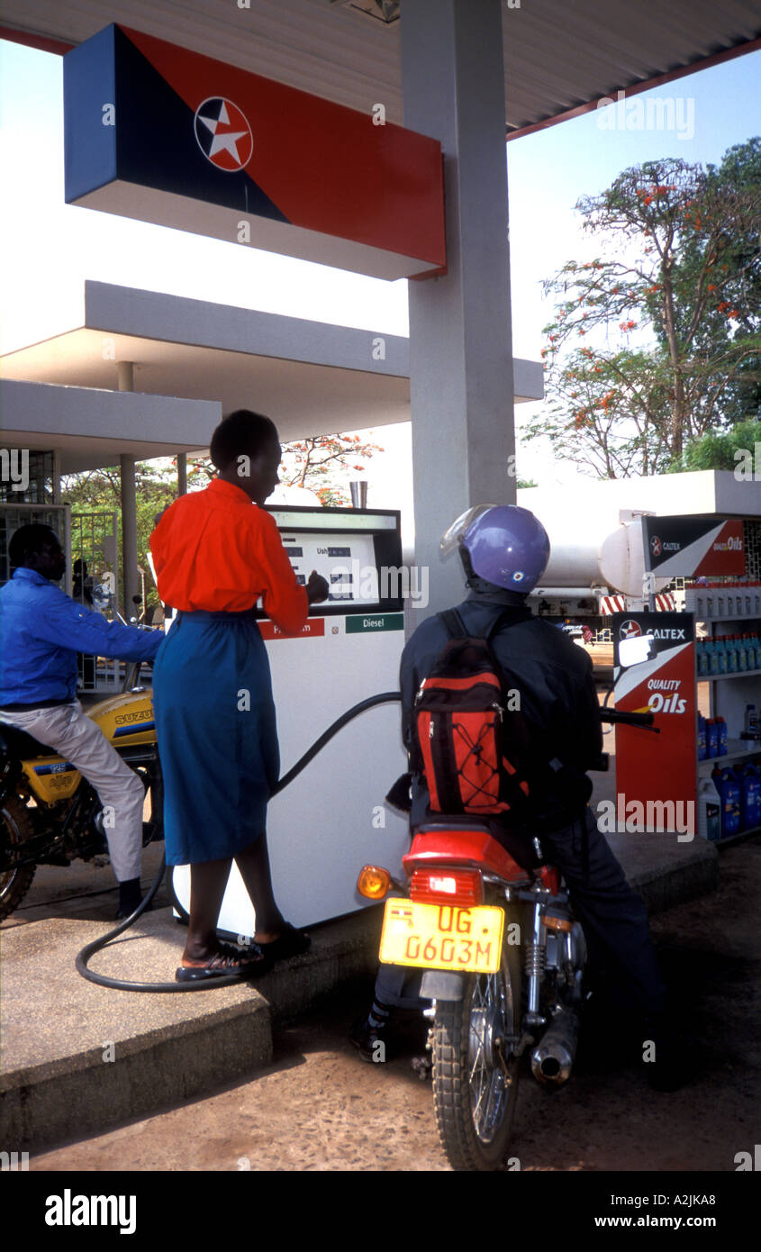 At a petrol station in Uganda a female petrol attendant is at the pump