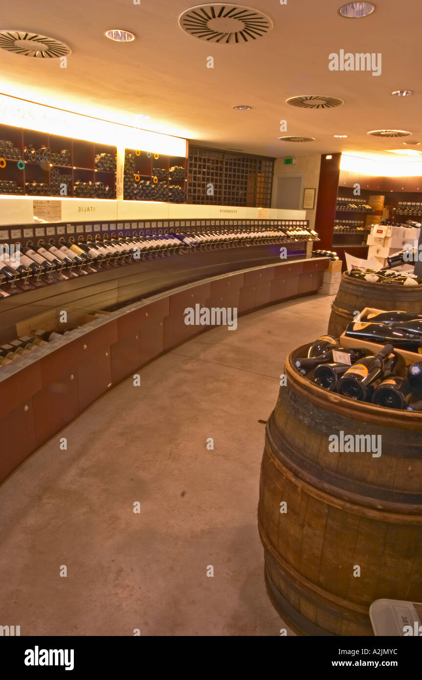 A curved display of bottles and a barrel used to present bottles The