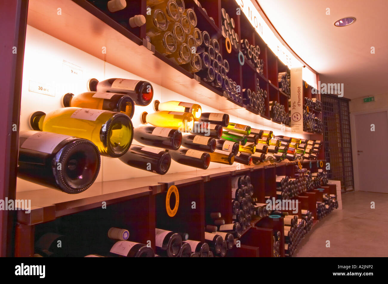 A curved display of bottles. Backlit The Lavinia wine shop in Paris