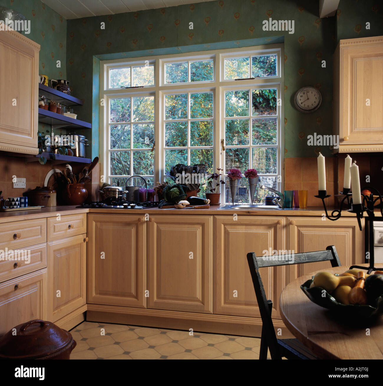 Pale wooden units in dark green kitchen Stock Photo - Alamy