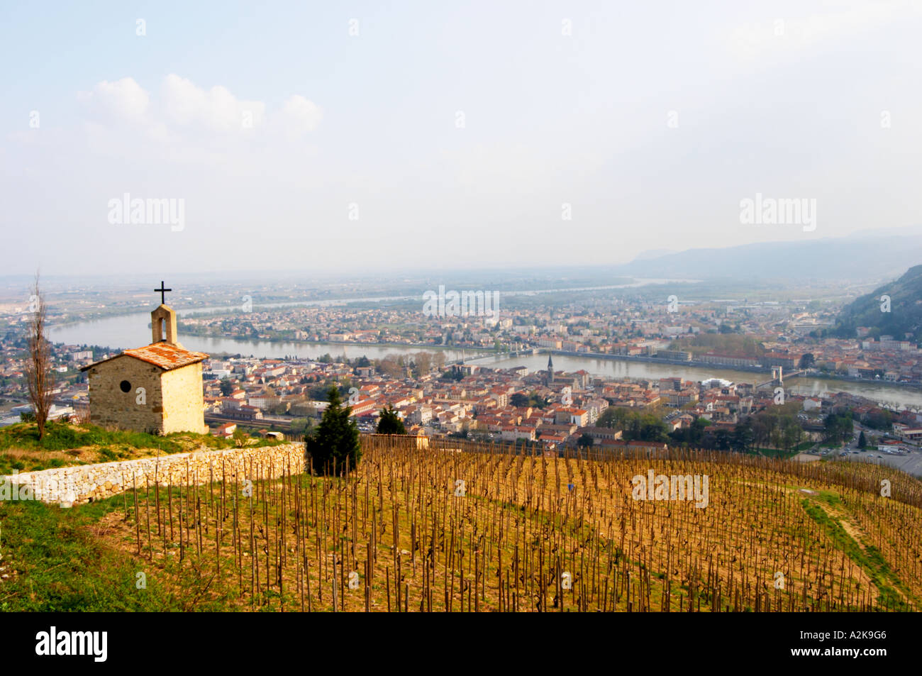 The Hermitage chapel on top of the hill with a view across the river on Tournon. The Hermitage vineyards on the hill behind the Stock Photo