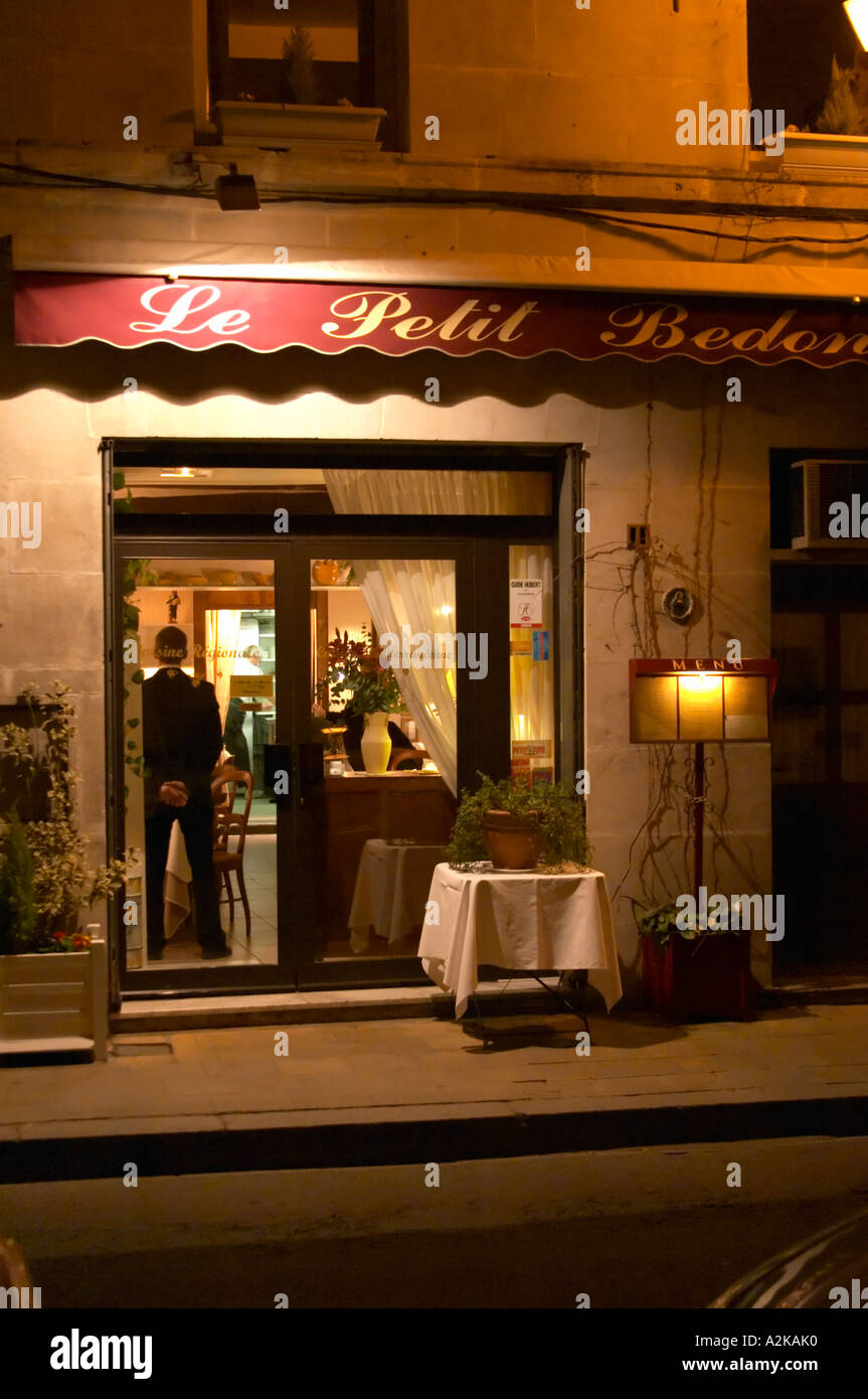 The restaurant Le Petit Bedon at night with the waiter standing inside the door.  Avignon, Vaucluse, Provence, Alpes Cote d Azur, France, Europe Stock Photo