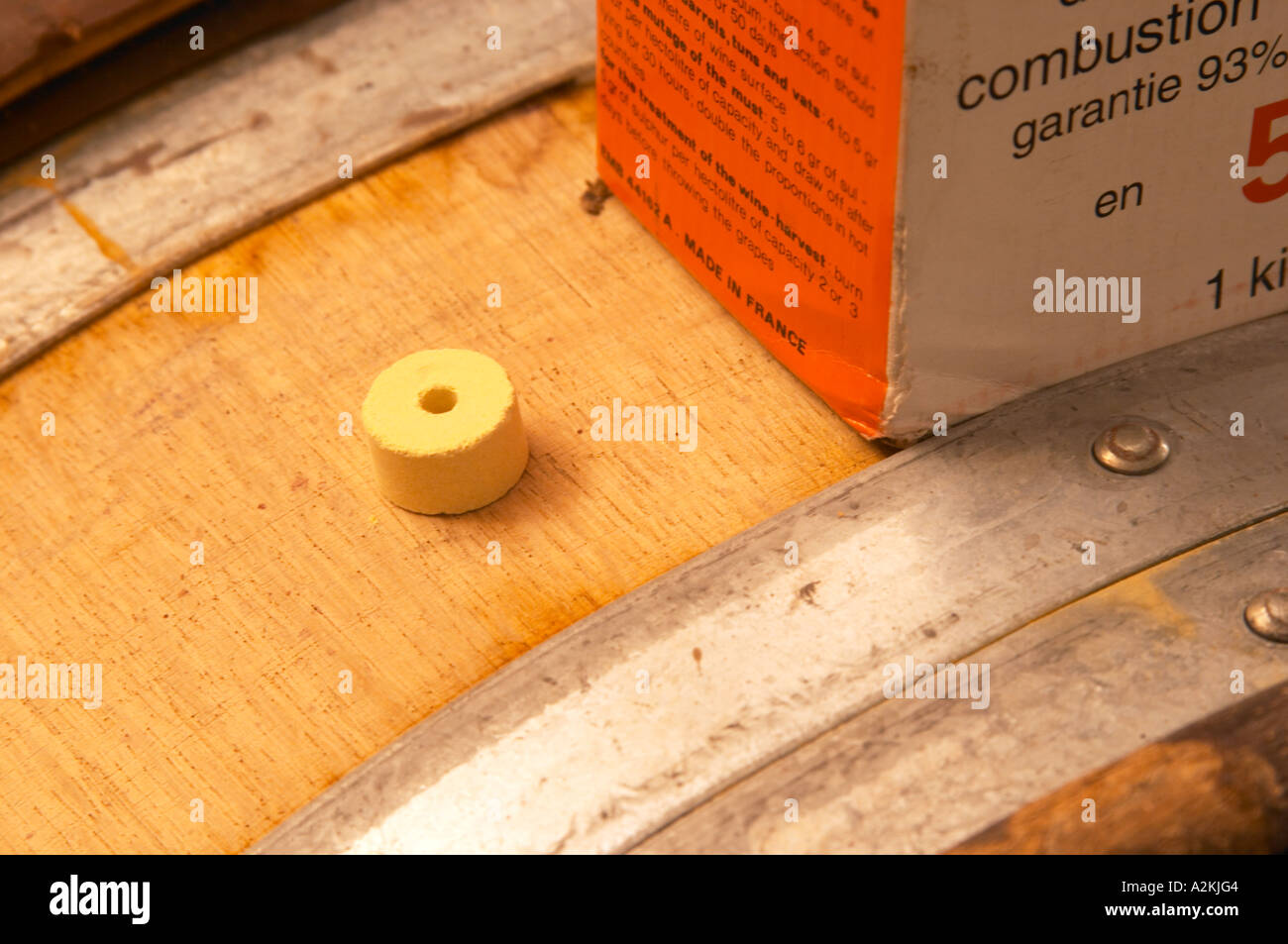 Detail of a sulphur pellet on top of a wooden barrel and a box of