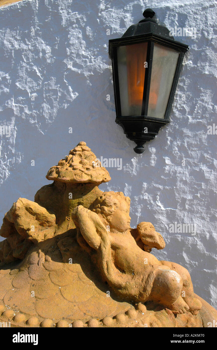 terracotta piece and old lantern in front of a wall Stock Photo