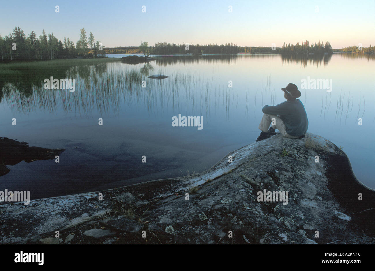 man sitting at a lake looks over the water Hidden Lakes Ingraham Trail Stock Photo