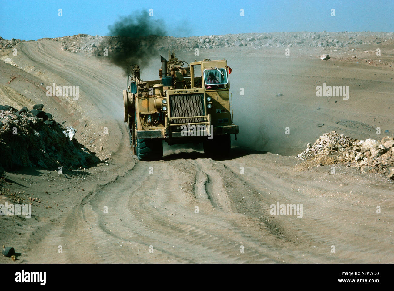 Huge Caterpillar tractor belching smoke building roads Saudi Arabia Stock Photo