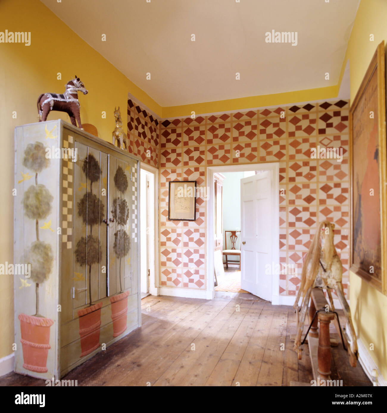 Landing with patterned wallpaper and antique rocking horse Stock Photo
