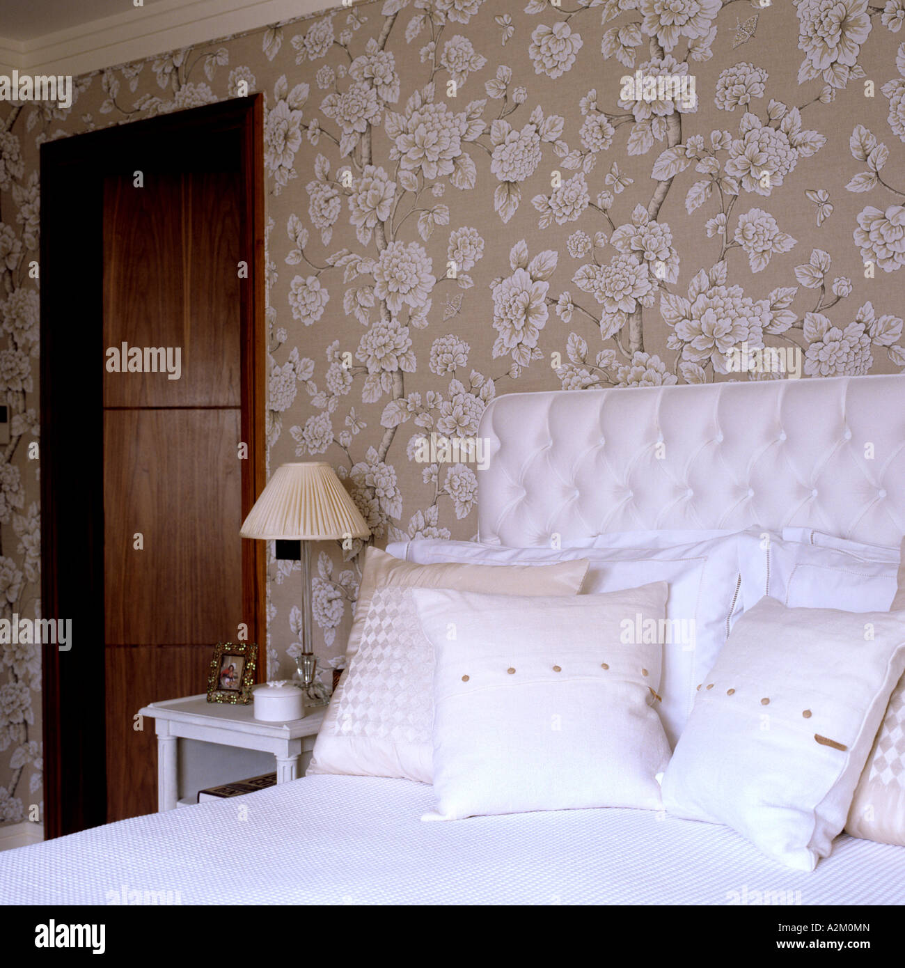 Bed With Cushioned Headboard In Bedroom With Floral