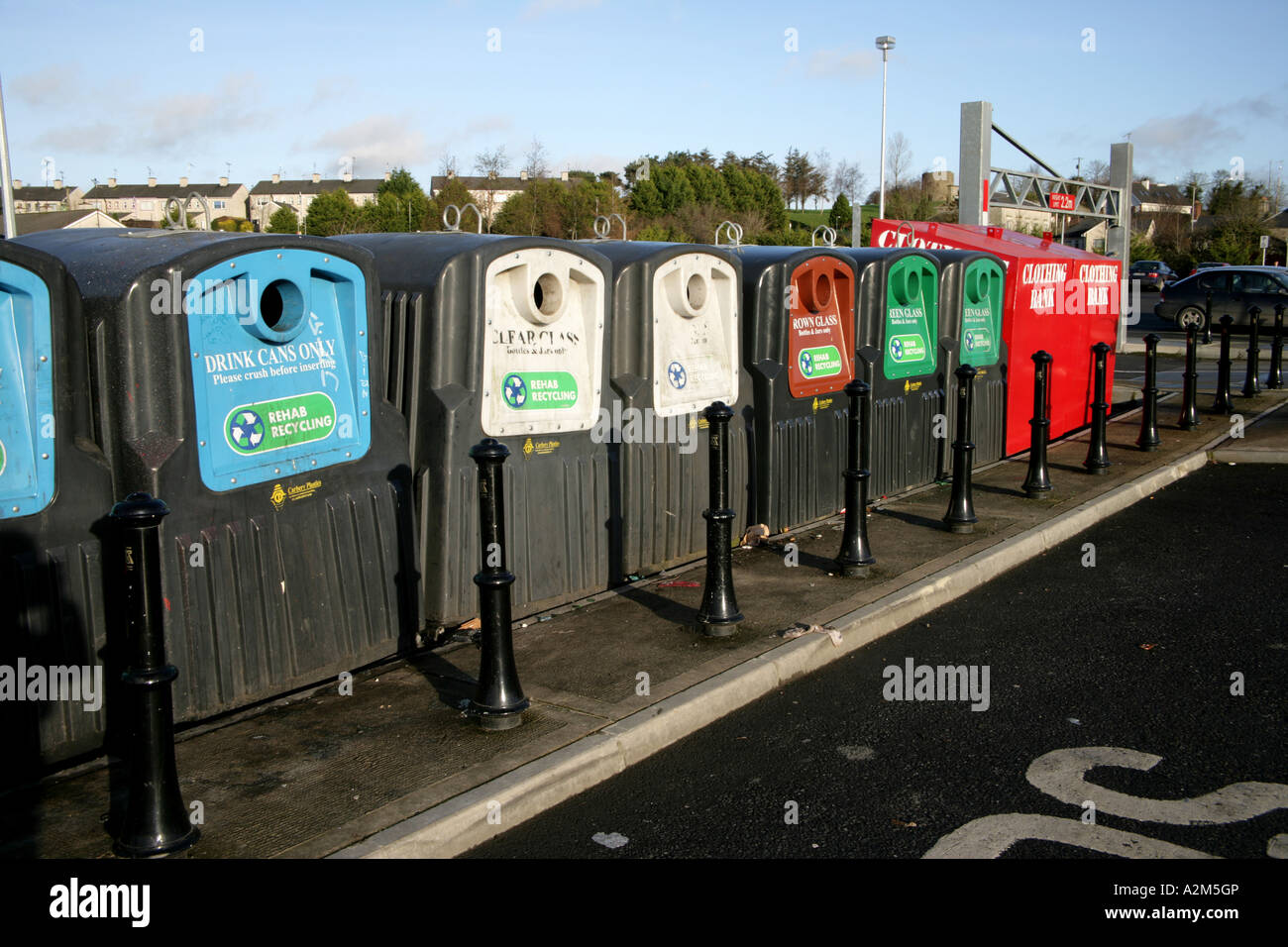Recycling bins for bottles and clothes in supermarket car park Stock