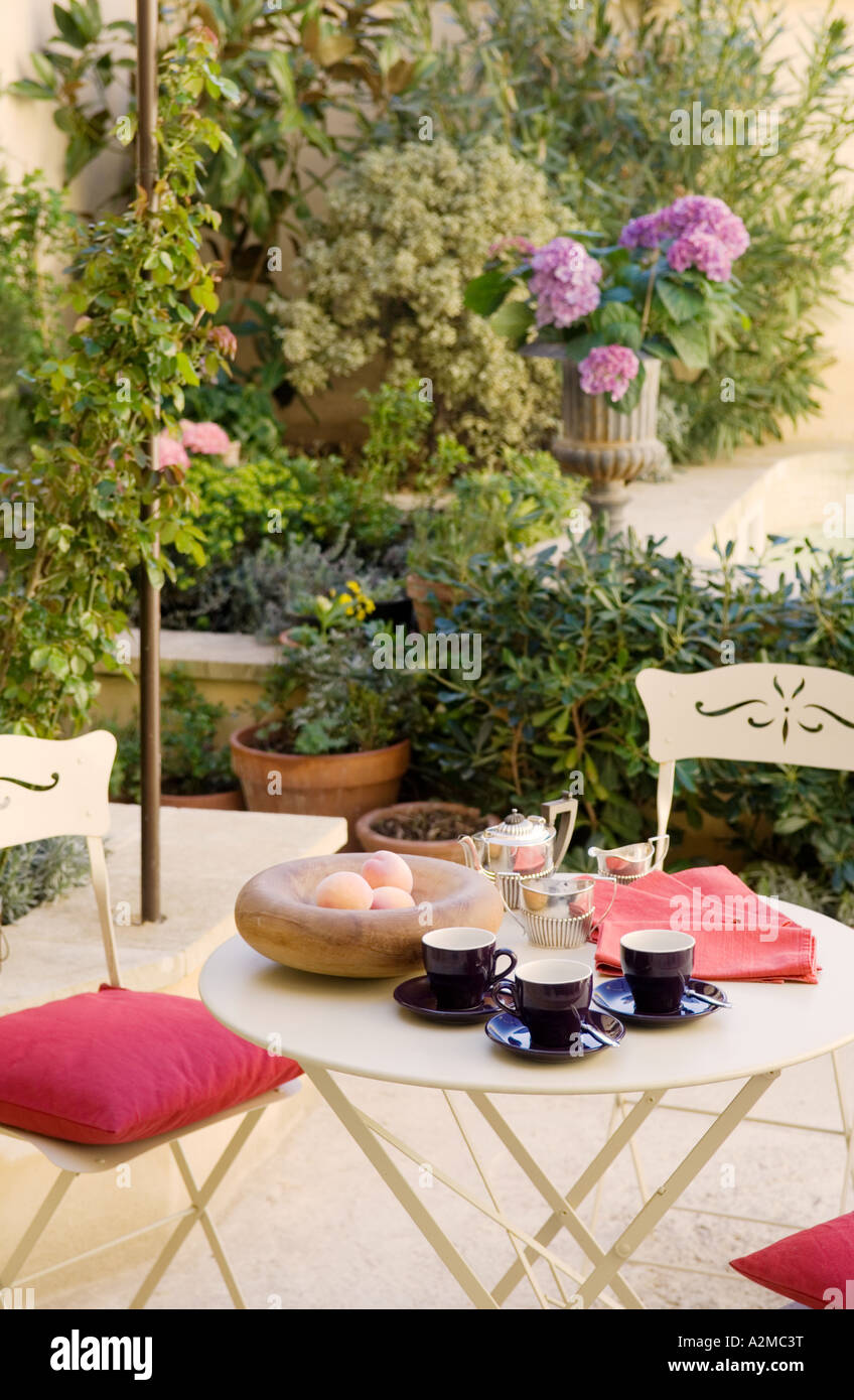 Table with cups and fruit bowl set on an outside patio Stock Photo