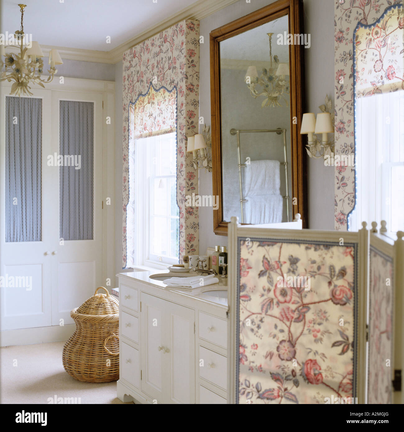 Floral patterned blinds and dressing screen in bathroom of English country house Stock Photo