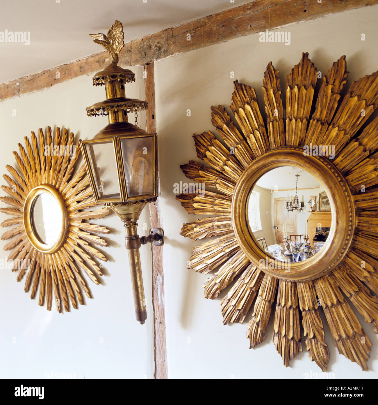 Pair of golden sunburst mirrors with antique wall lantern Stock Photo