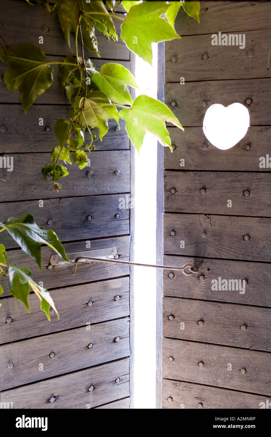 Heart carved in studded door of garden gate Stock Photo