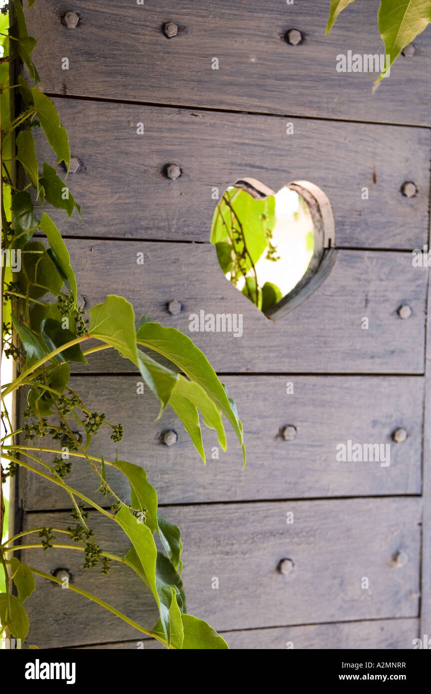 Heart carved in studded door of garden gate Stock Photo