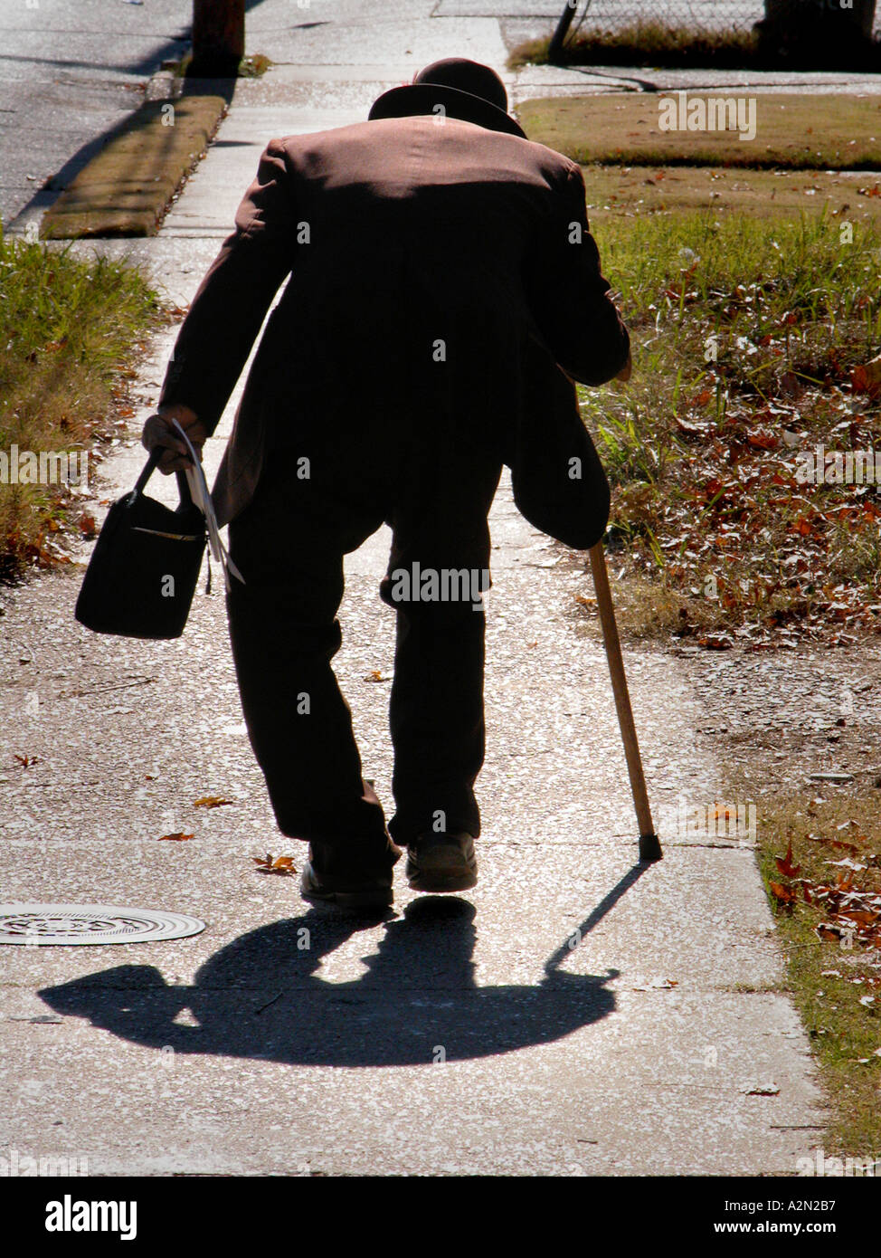 Very old real 88 year old man on the way home from Church in Alabama and bent legs and cane and had well dressed and happy every day living alone Stock Photo