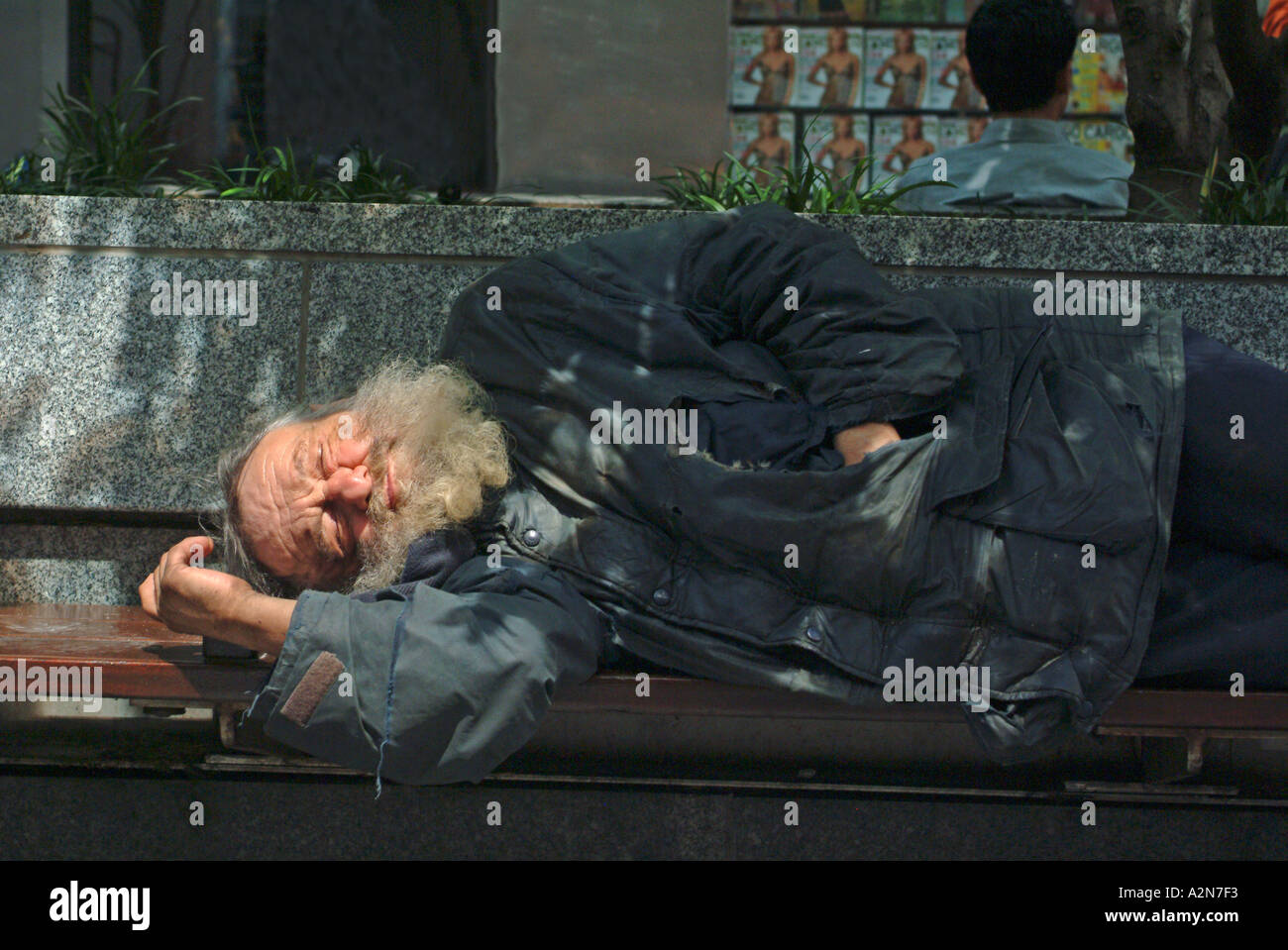 homeless man sleeping on bench in New York City Stock Photo - Alamy