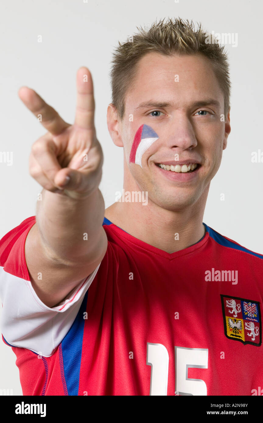 Portrait of male soccer fan showing victory sign and smiling Stock