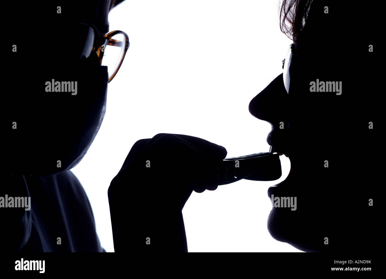 Silhouette of a dentist taking a dental impression. Picture by Jim Holden. Stock Photo
