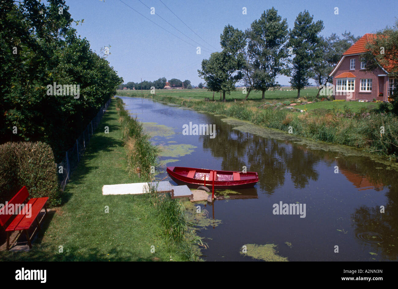 Boat moored in canal, Wynhamster Kolk, Dollart, East Frisia, Lower Saxony, Germany Stock Photo
