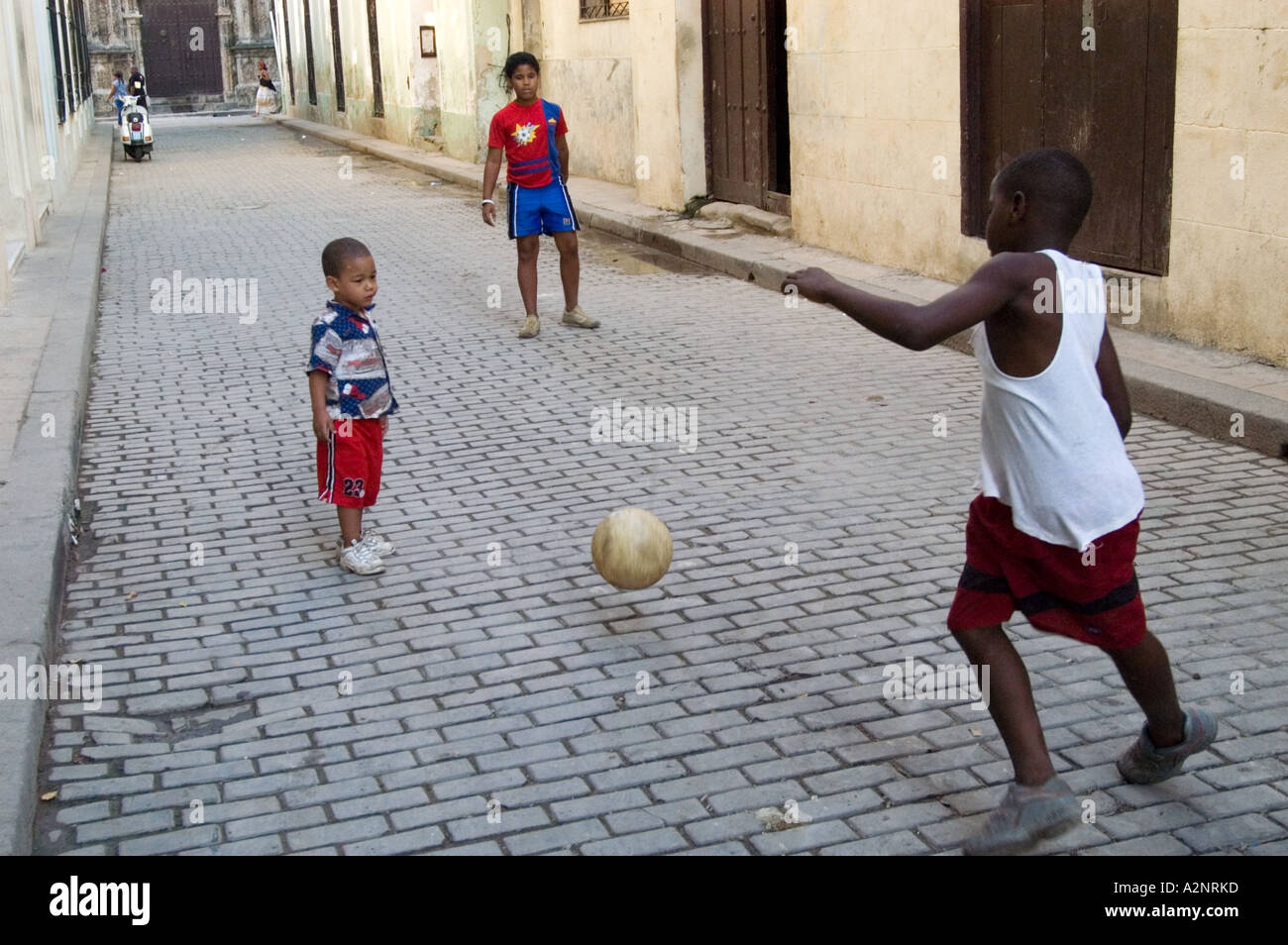 Children playing game of football in the street, Havana Cuba Stock Photo