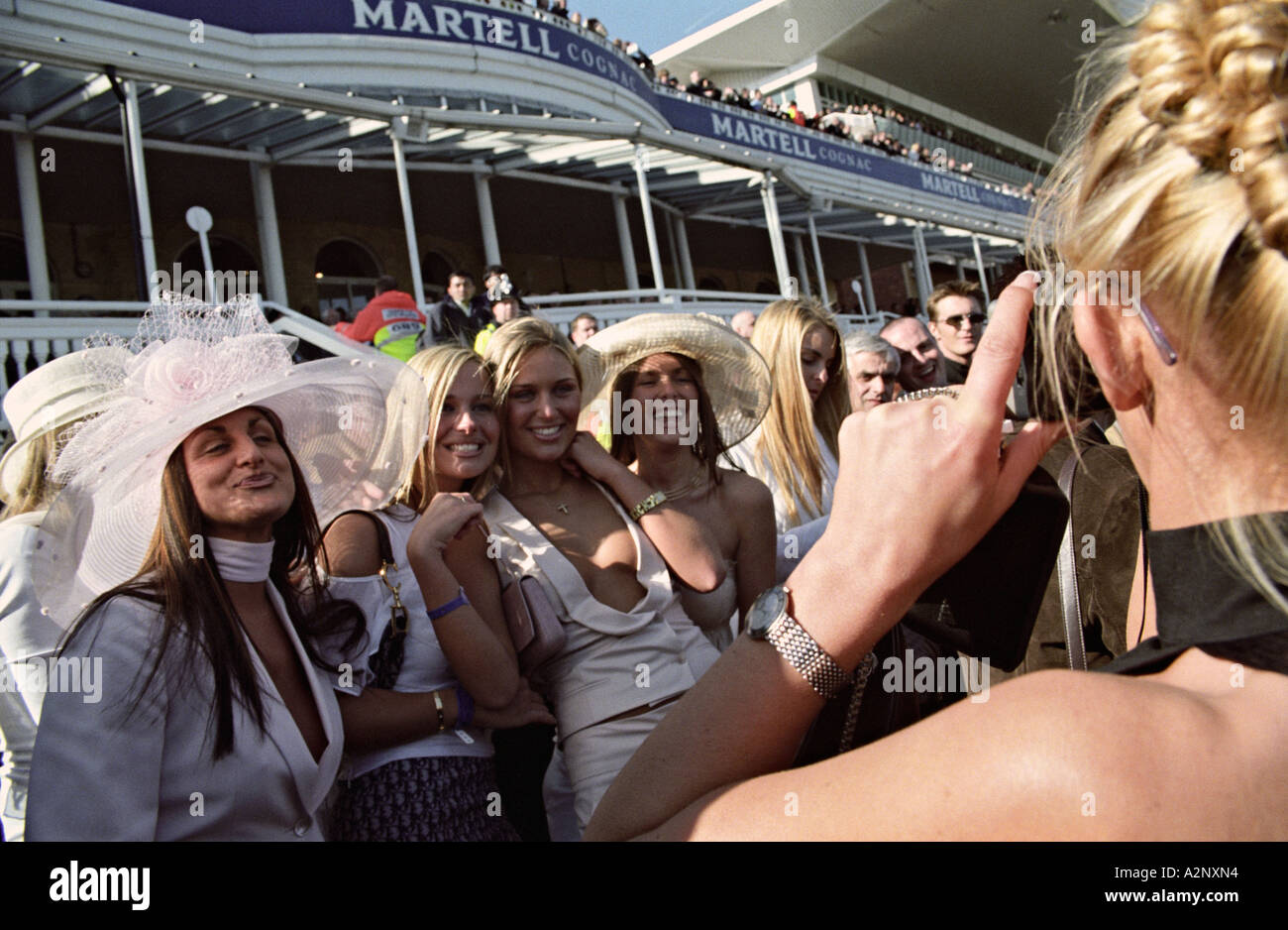 Aintree Racecourse, Liverpool UK. Young women pose for a photo at the Grand National horse race Stock Photo