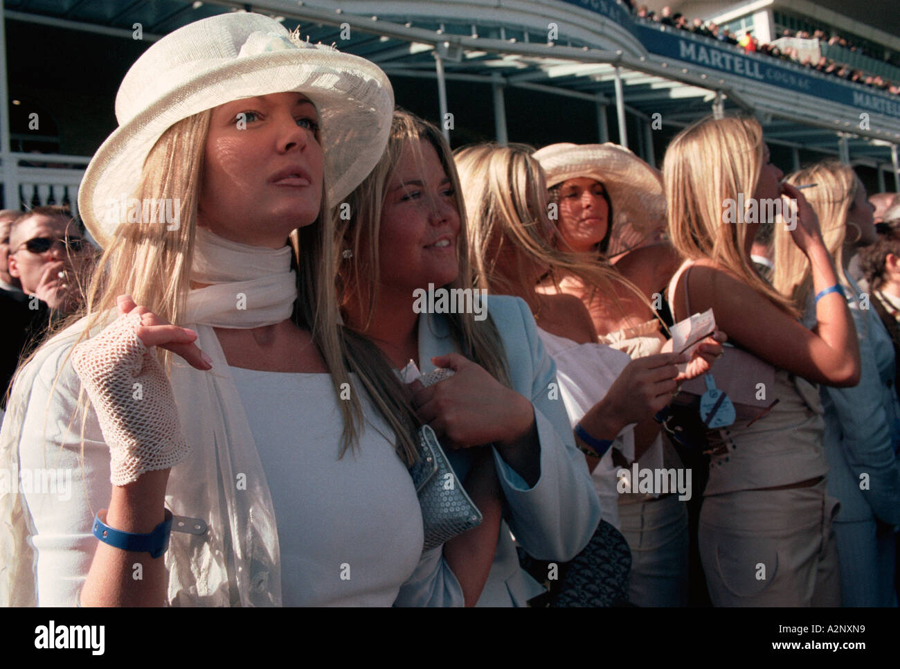 Aintree Racecourse, Liverpool UK.  Young women look on excitedly as the Grand National horse race draws to a close Stock Photo