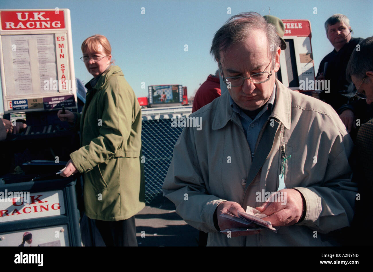United Kingdom, England, Aintree. A racegoer counts his winnings after collecting from the betting stand at the Grand National Stock Photo