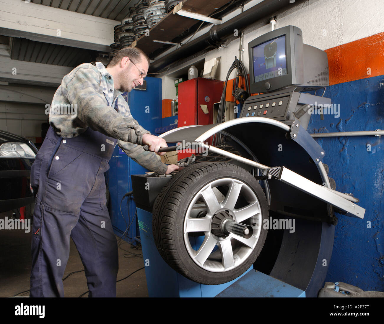 The Mechanic Frank Michels balances the tyres in the motor vehicle workshop Stock Photo