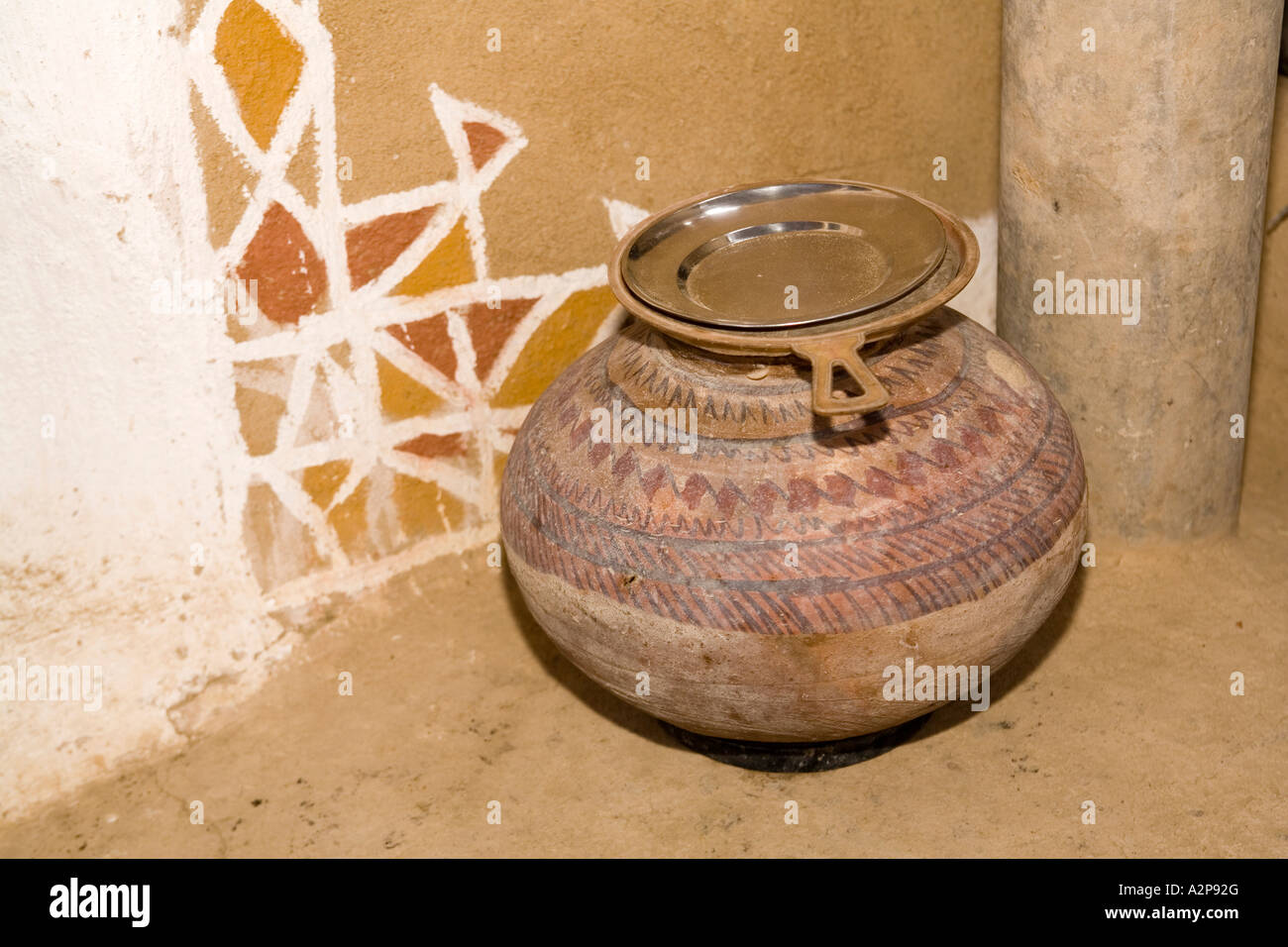 India Rajasthan Thar Desert village architecture decorated mud rendered wall and water pot Stock Photo