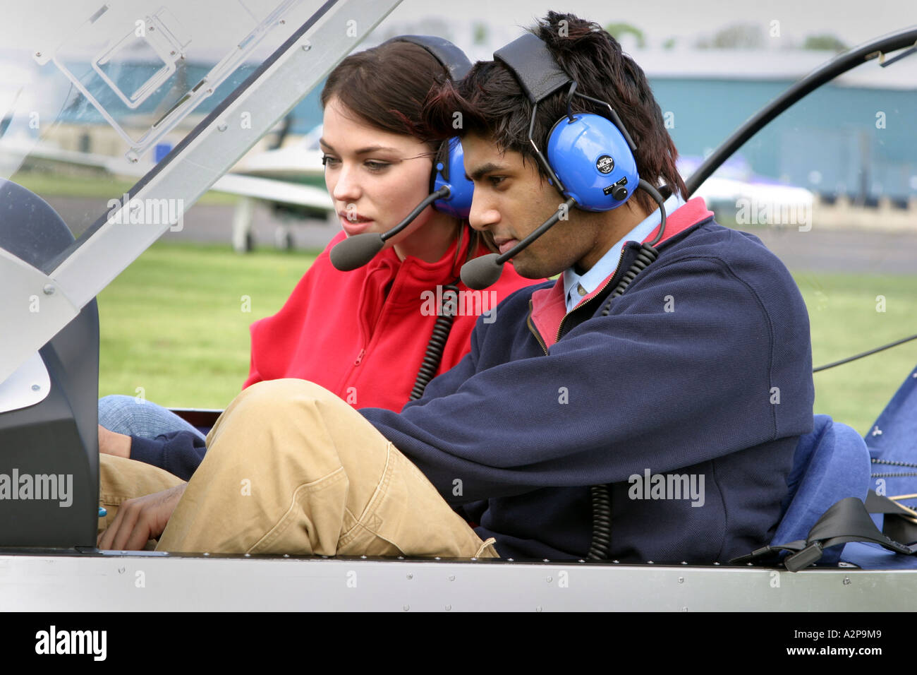 A young couple preparing for take off in a microlite aircraft Stock Photo