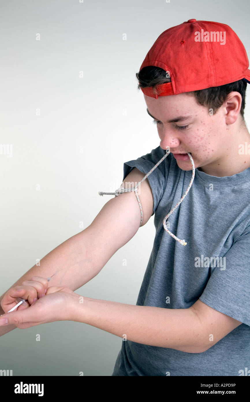 Young male youth self injecting drugs Stock Photo