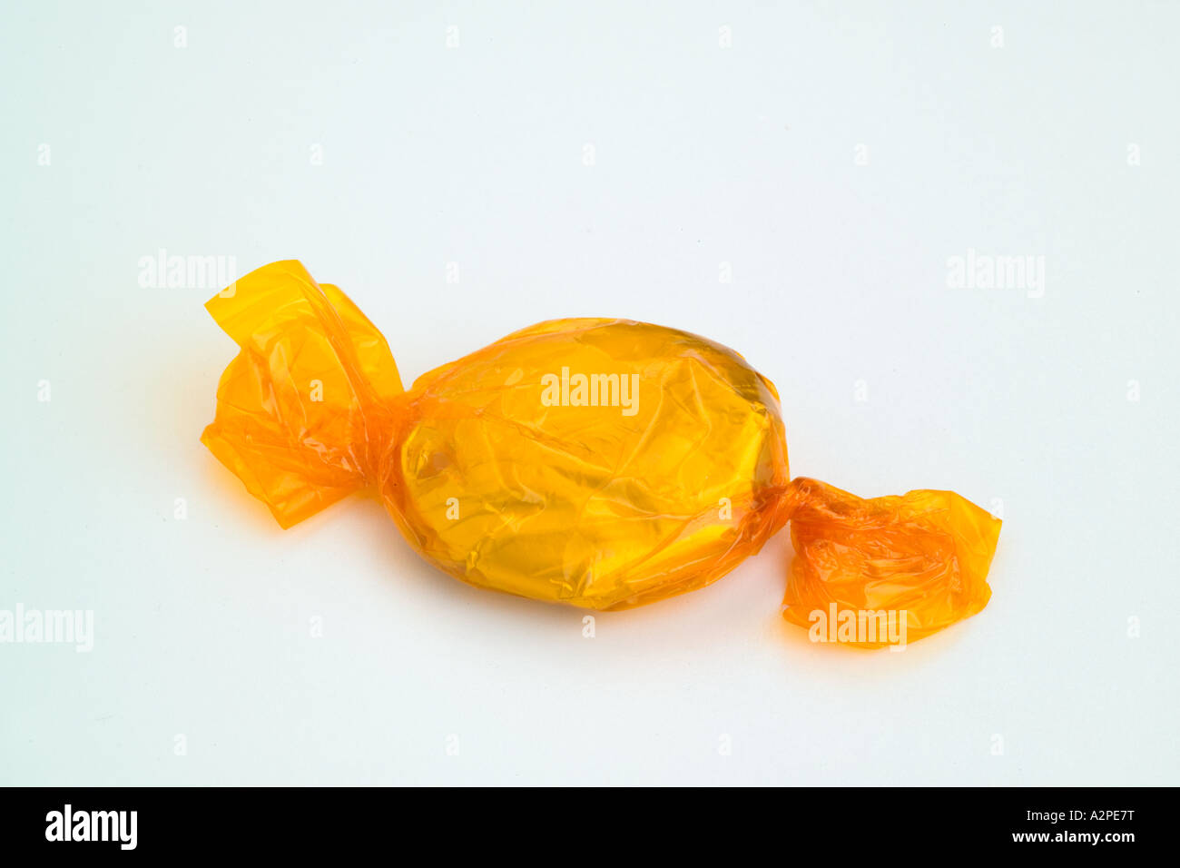 Yellow round cellophane wrapped toffee sweet Stock Photo Alamy