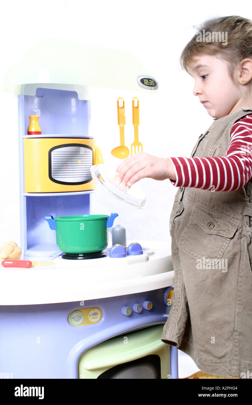 little girl playing in doll's kitchen Stock Photo