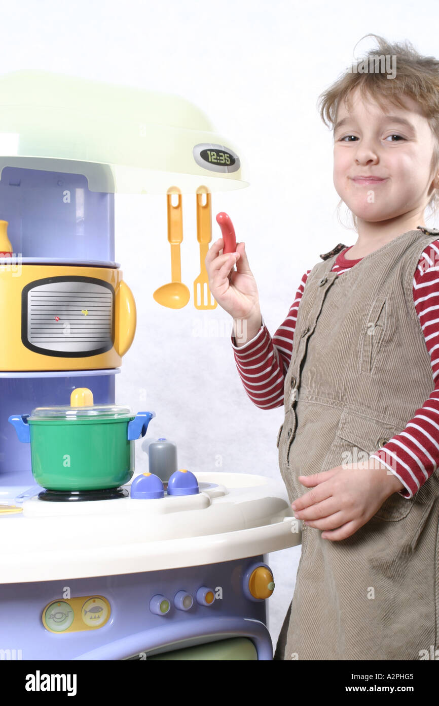 little girl playing in doll's kitchen Stock Photo