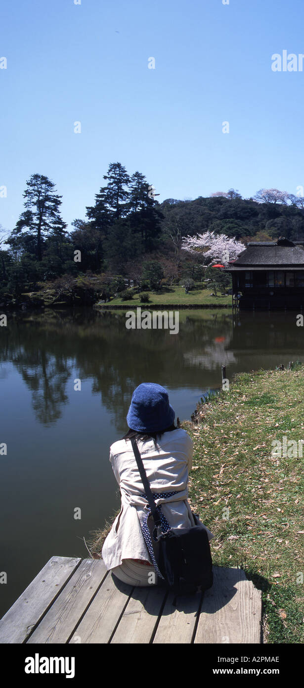 Hikone Castle Genkyu en Traditional Japanese Garden with Japanese girl contemplating pond Stock Photo