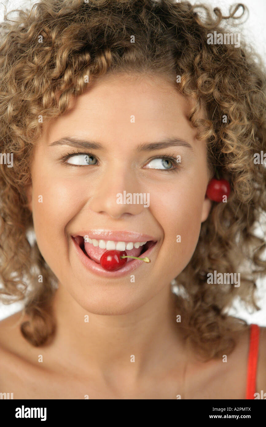 Woman with cherry in her mouth Stock Photo Alamy