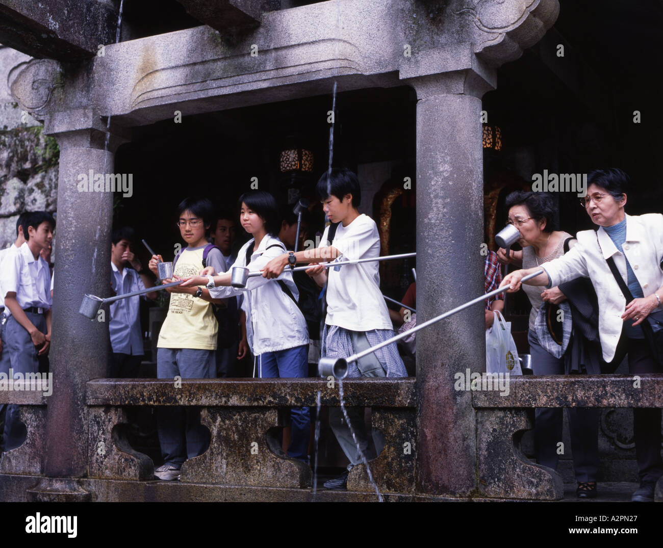 Students scoop water from the spring at Kiyomizu Temple The water is said to provide longevity Stock Photo