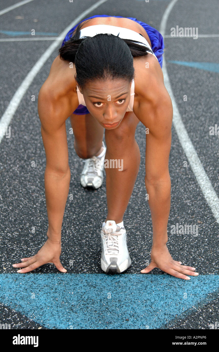 Black African American woman runner at the starting line of a track and