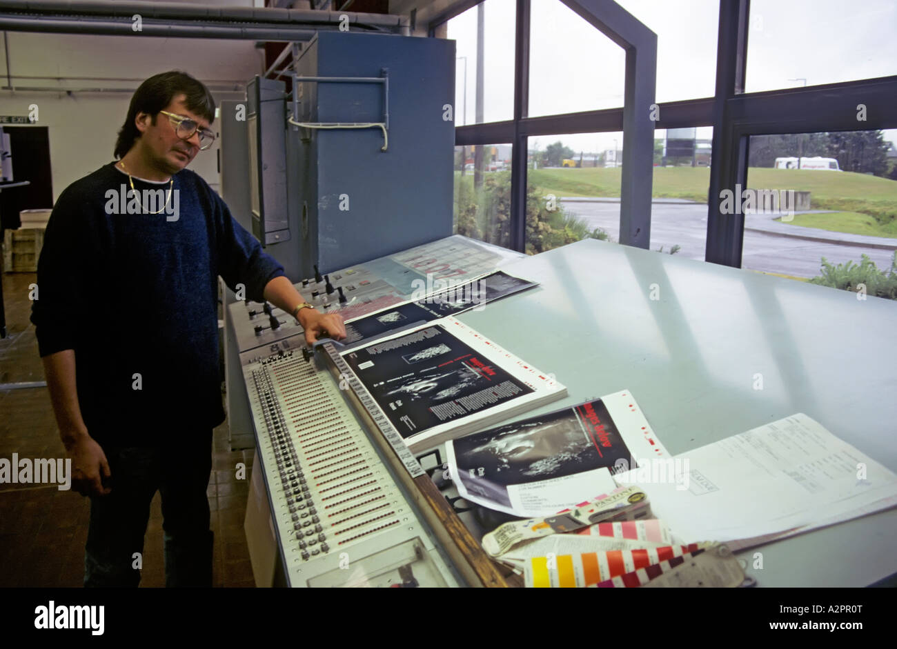 Man examining printing proofs using daylight on light table Stock Photo