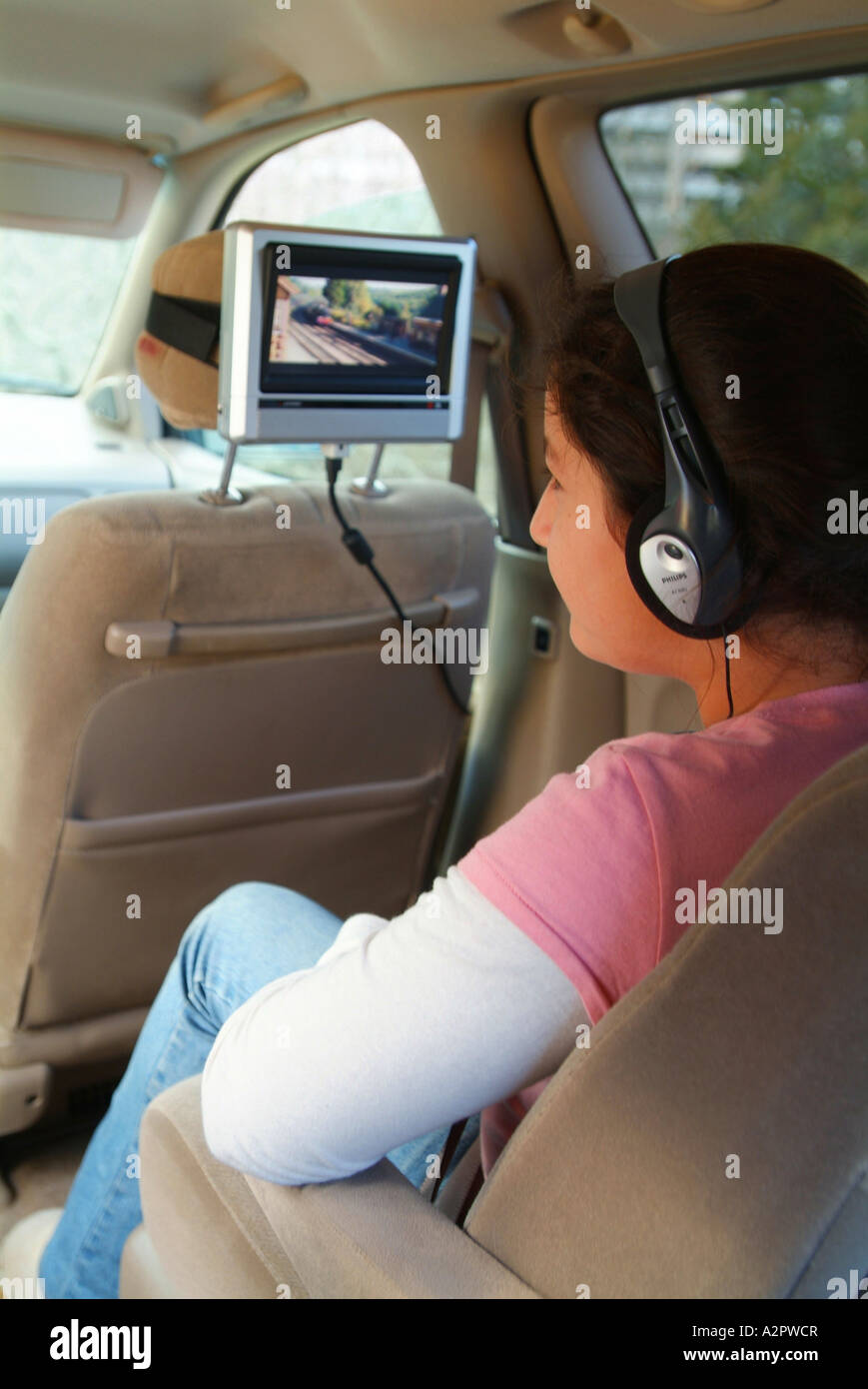 A 12 Year Old Hispanic Girl Watches A Movie On A Dvd Player In A