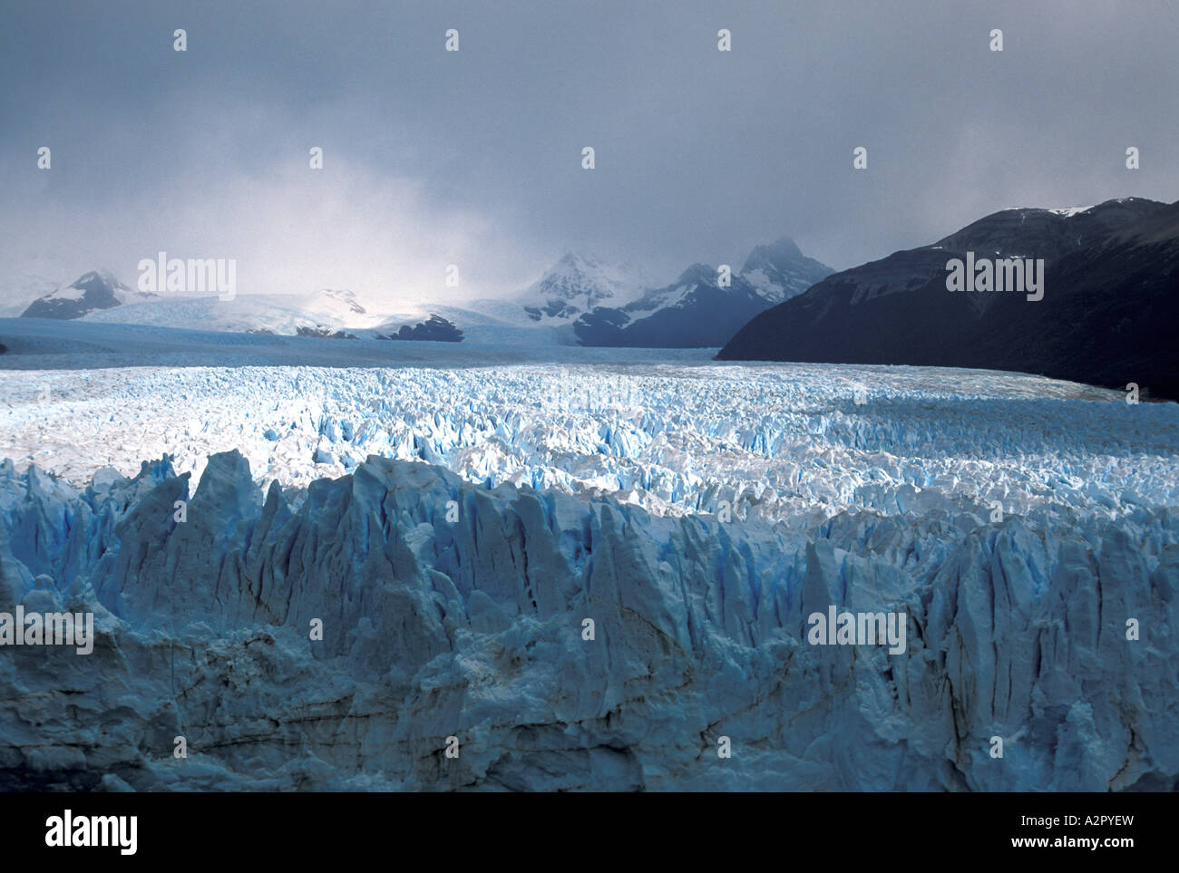 Moreno Glacier, Argentina with the sun breaking through clouds onto the glacier crevases in the distance Stock Photo