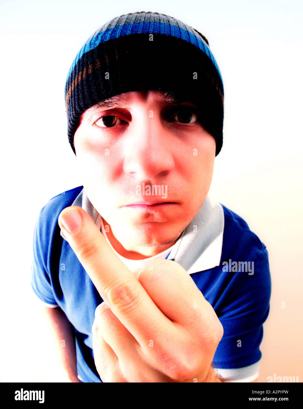A full frame image of a white caucasian male with wooly hat on gesturing rudely with his finger Stock Photo