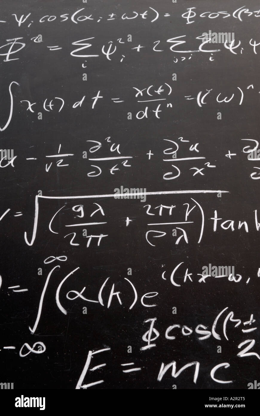 Complicated math wave equation formula ending with E=MC2 with chalk on a blackboard Stock Photo