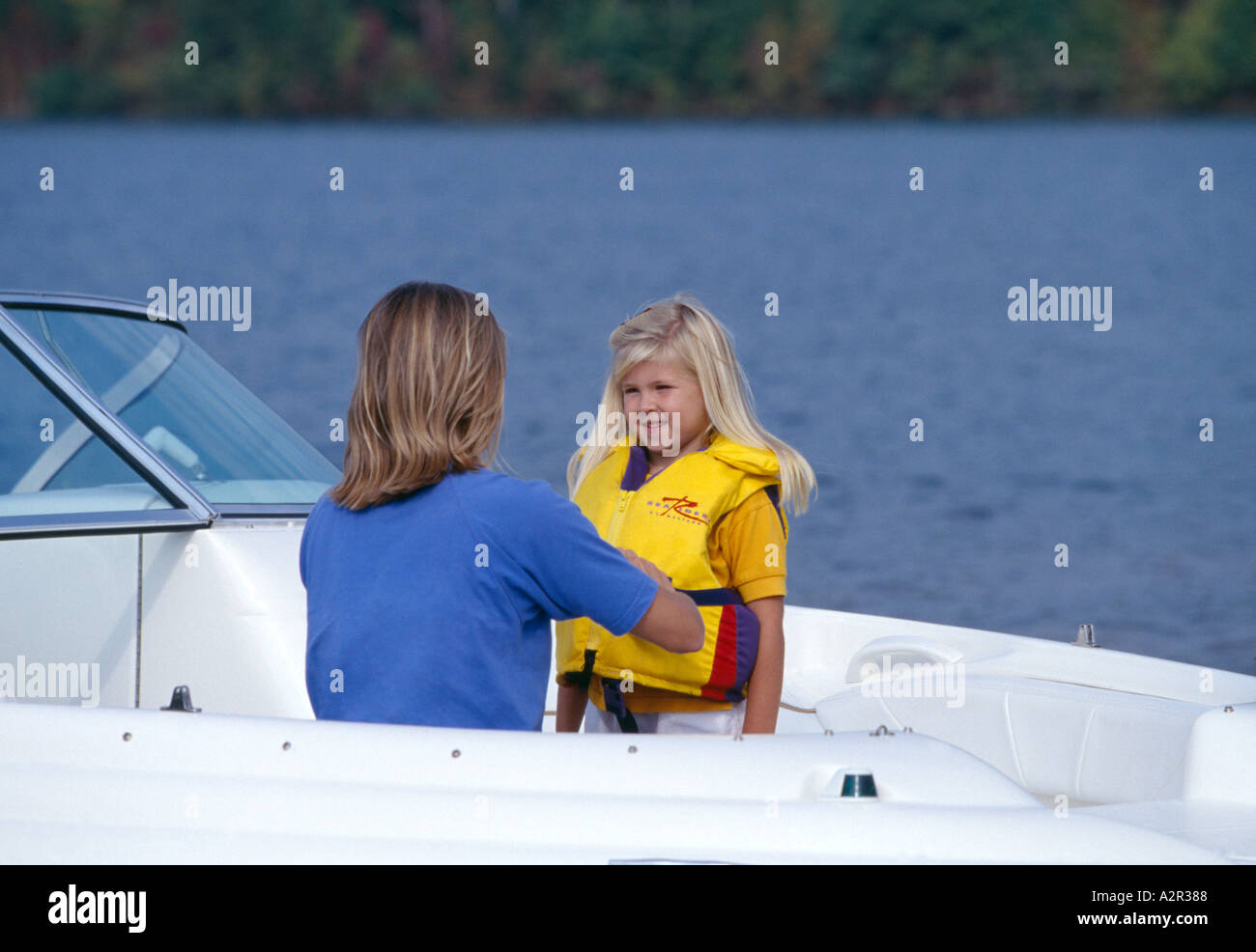 Mother adjusting PFD on daughter in boat on lake near Knoxville TN Stock Photo