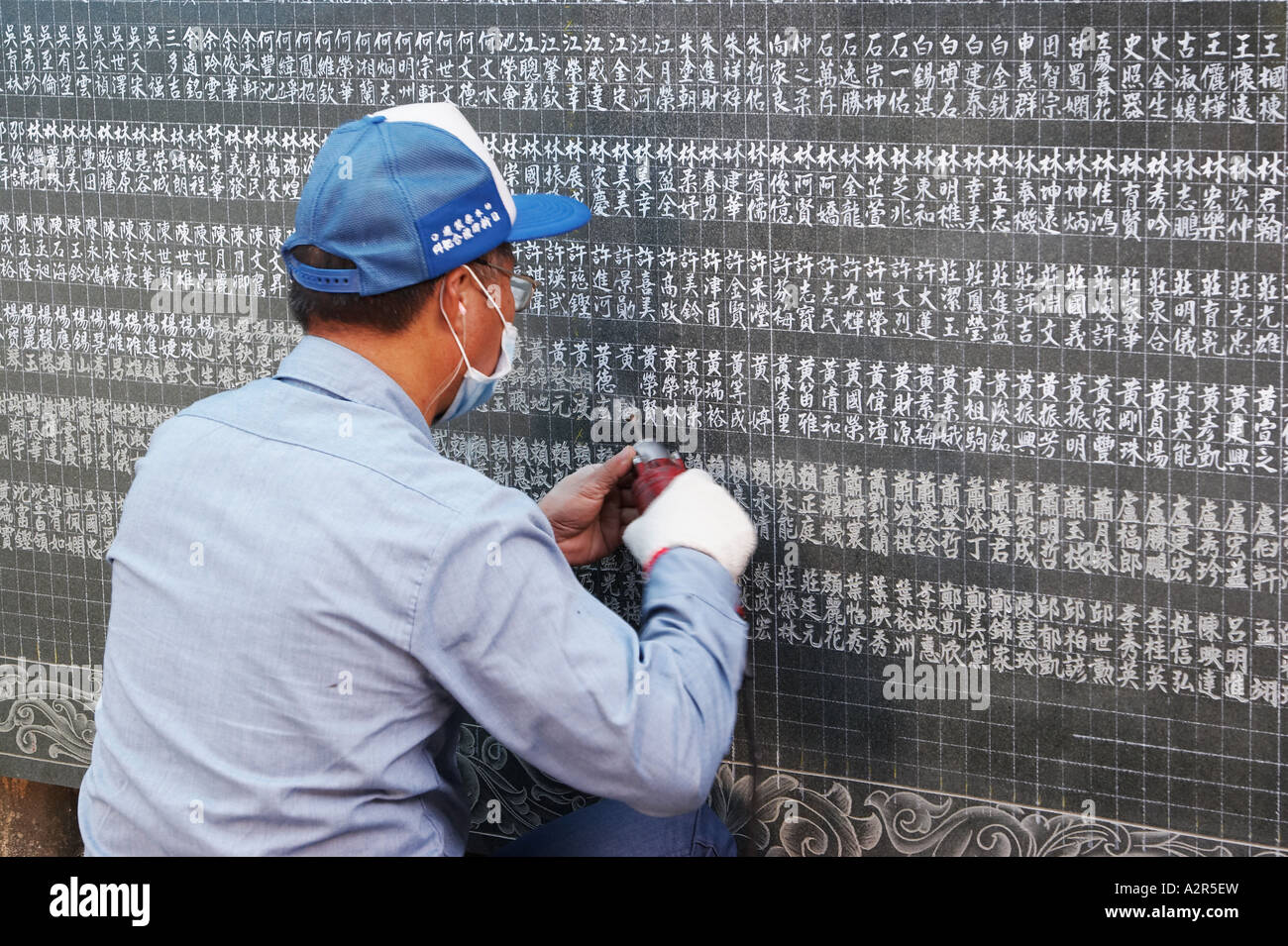 Man Engraving Names Onto Marble Tablet Stock Photo