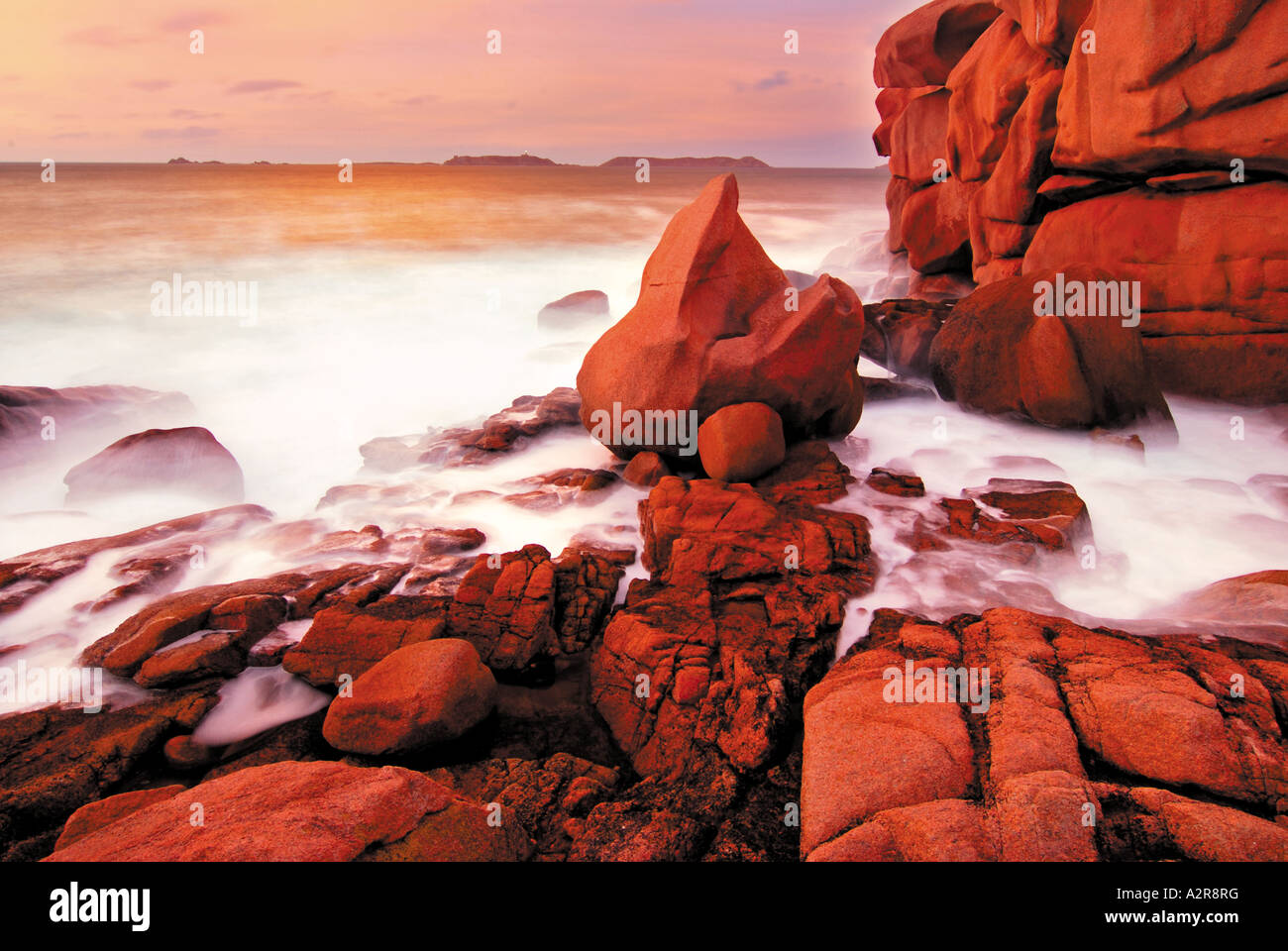 Rocks and water reflection at twilight, Cote Granit rose, Ploumanac´h, Brittany, France Stock Photo
