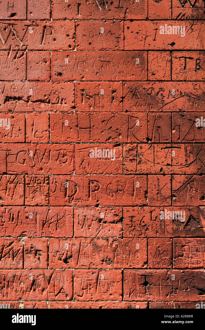Graffiti craved in brickwork on old school walls Dedham North Essex UK Stock Photo