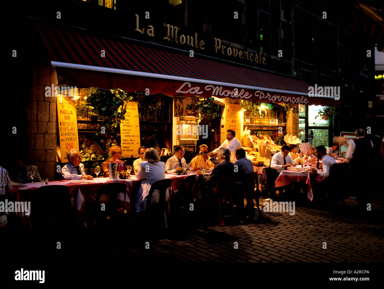 Open air tables outside fish restaurants in Rue des Bouchers near grand Place Stock Photo